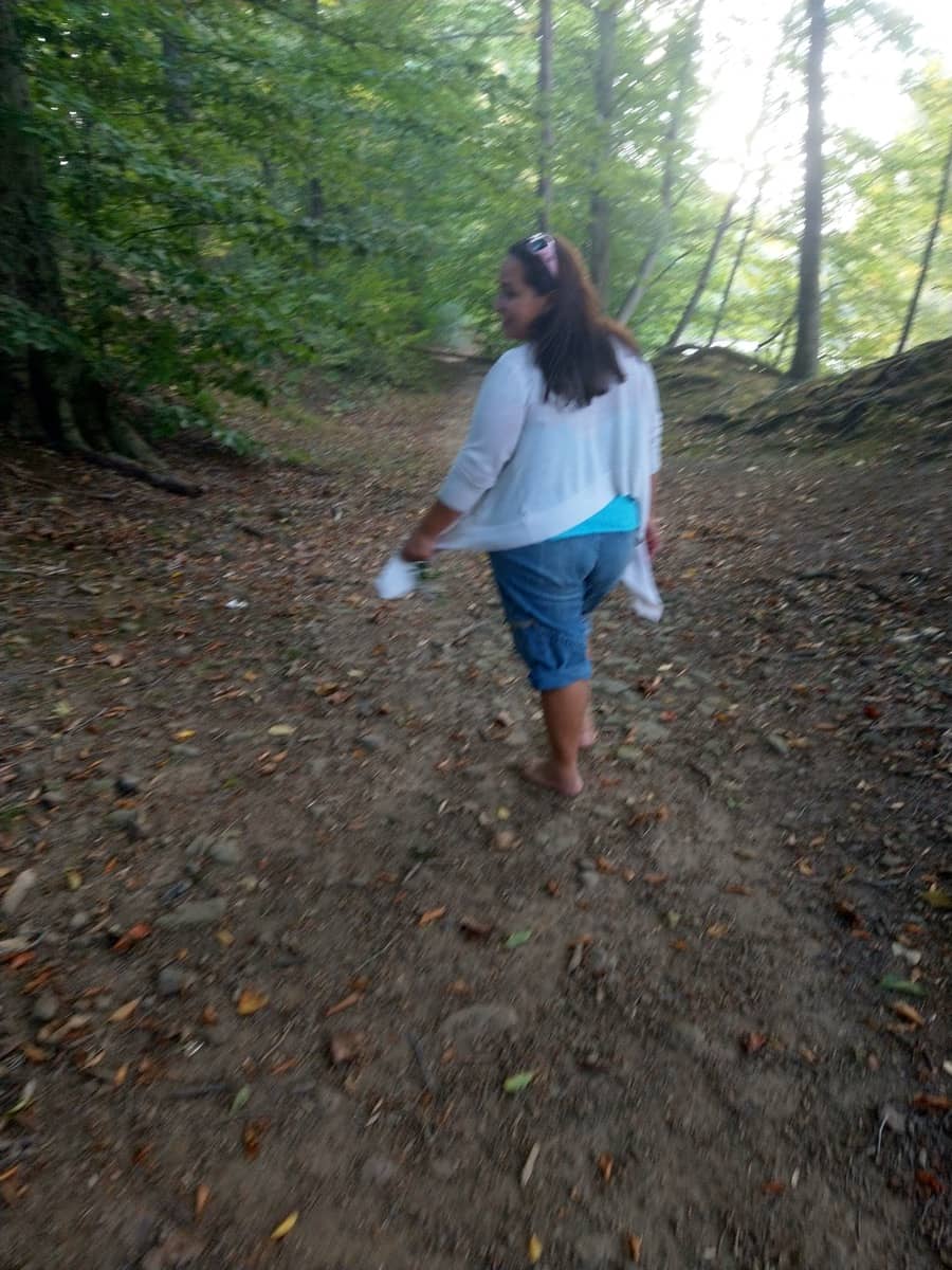 Jacqui hikes barefoot on a dirt covered trail in Bucks County, PA